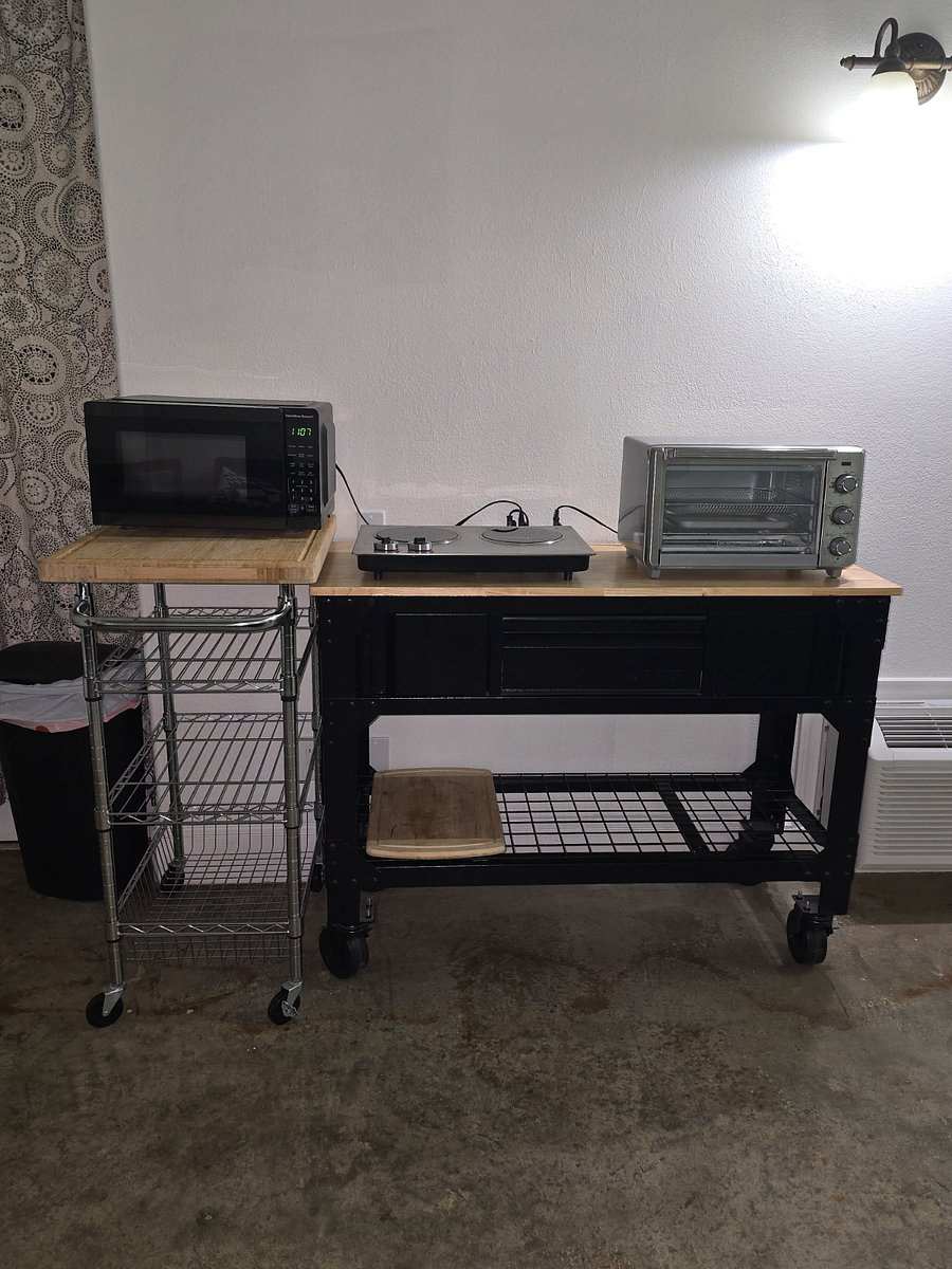 The kitchenette in Studio 201: a microwave, a two-burner hot plate and a toaster oven on wood-topped rolling carts.