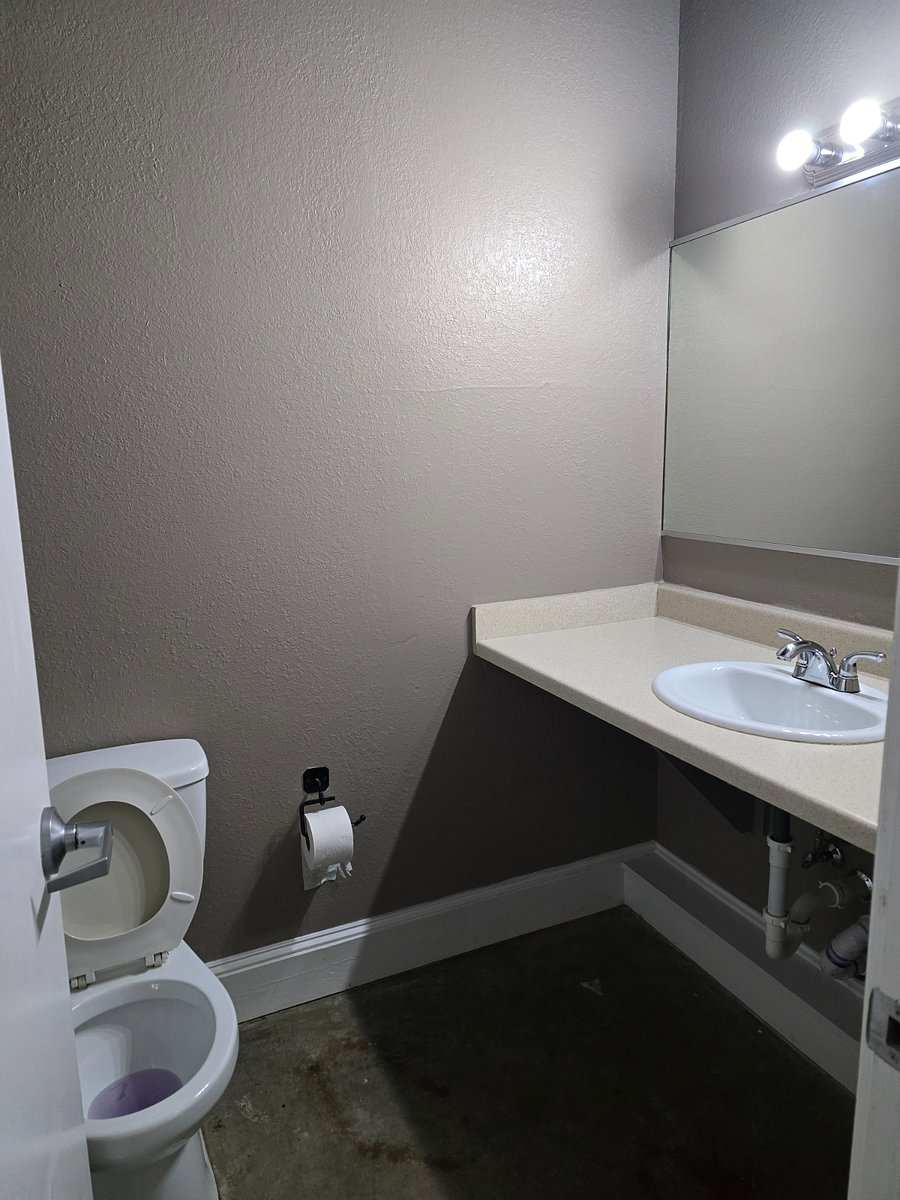Studio 204 bathroom: a vanity sink with a mirror, and the toilet.